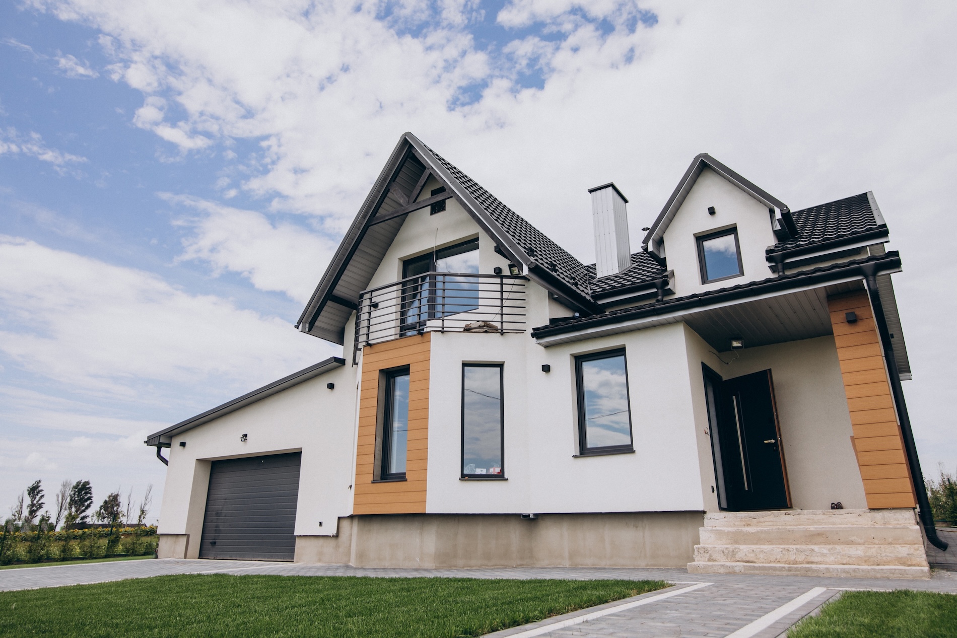 Modern two-story home with a white exterior and dark roof, representing ADU projects in Long Beach and Lakewood