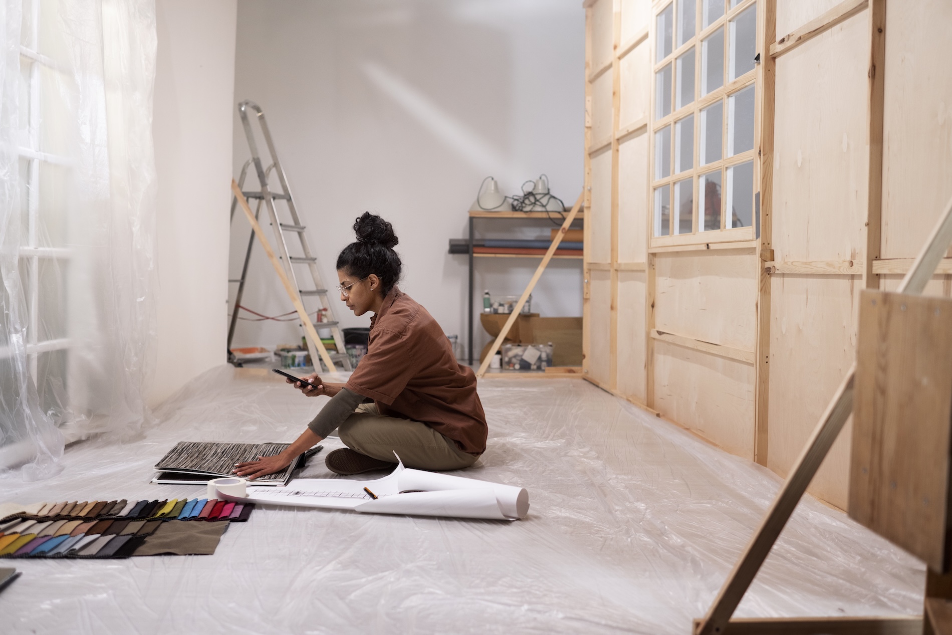 Designer reviewing floor plans and finish samples inside an ADU under construction during a garage conversion.